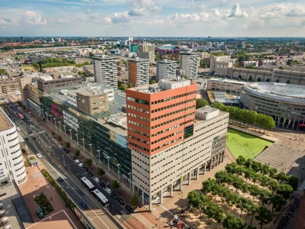 Luchtfoto van het Johanna Westerdijkplein in Den Haag met omliggende kantoorgebouwen en stadsontwikkeling.